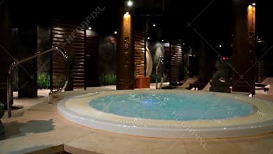 Relaxation pool in spa with waterfall. Empty luxury spa with jacuzzi and swimming pool. Jacuzzi in the sauna. Wellness