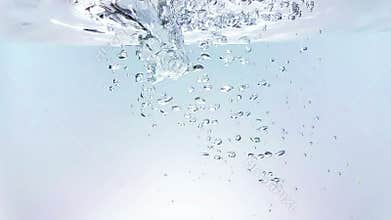 Fresh bubbles splash falling down into water, shot in slow motion on white background, purity and clean