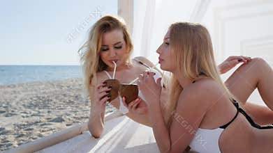 Tropics, white cloth, beautiful girlfriends lying at bungalow, wind