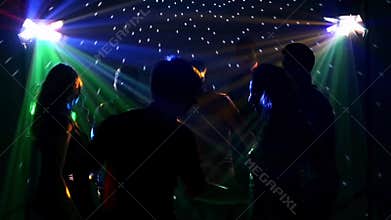 Happy group of friends dancing at a nightclub and