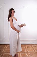 Pregnant woman in studio with book