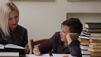 Young student engaged in the lessons with his teacher. Helping.