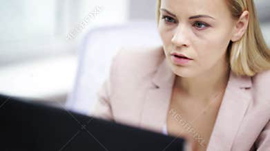 Stressed businesswoman with computer at office