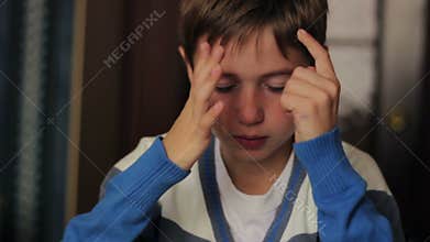 Sick boy blowing his nose into a napkin while