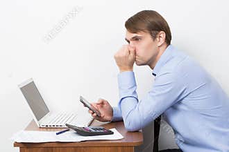 Man with a calculator at his desk in the office