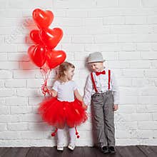 Little kids holding and picking up heart balloons. Valentine's Day and love concept, on white background