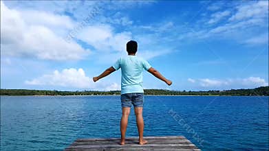 A man standing in the wood sea bridge and Open arms, shouting for his release