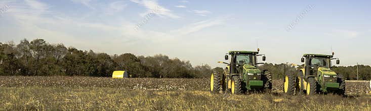 Panorama of cotton field with two tractors