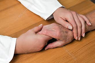 Hands of a nurse and a former senior
