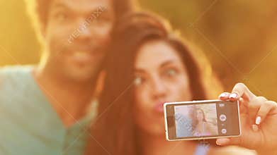 Young, beautiful couple taking a funny selfie