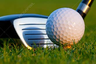 Golf ball and driver on golf course