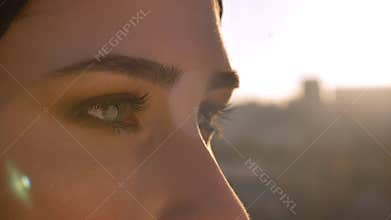 Closeup side view shoot of young attractive female face in hijab with eyes looking forward with urban city on the
