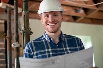 Portrait Of Architect Inside House Being Renovated Studying Plans