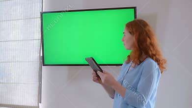 Businesswoman standing near green screen.