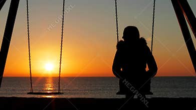 Woman alone swinging looking at empty seat