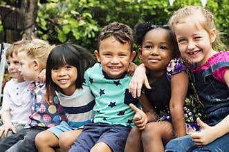 Group of kindergarten kids friends arm around sitting and smiling fun