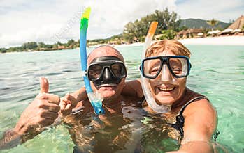 Senior happy couple taking selfie with scuba snorkeling masks