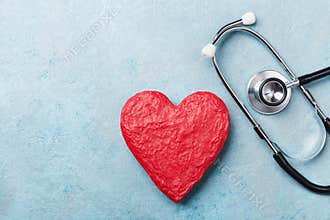 Red heart shape and medical stethoscope on blue background top view. Health care, medicare and cardiology concept.