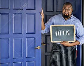 A cheerful small business owner with open sign