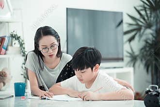 Asian boy with mother teaching and learning your homework at home