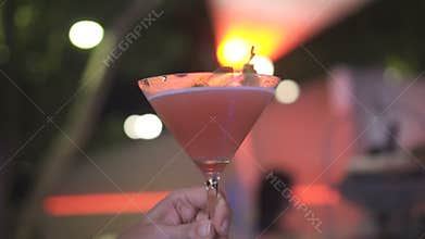 Woman holding alcoholic cocktail in the club