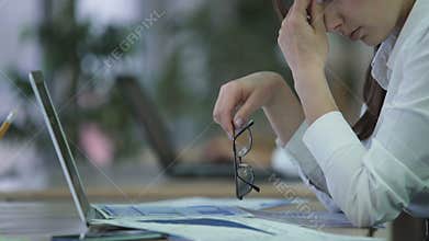 Exhausted woman manager taking off glasses and rubbing eyes, overworked employee