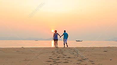 Couples of asian man ,woman happiness on sea beach with sun rising sky
