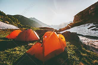 Camping tents in mountains morning sun landscape