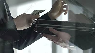 Politician checking dollar bills cash in open briefcase, bribe money offering
