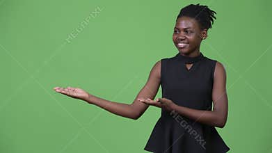 Young beautiful African businesswoman showing something