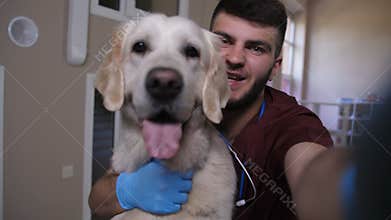 Vet making selfie on phone with dog at clinic