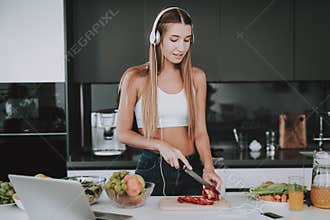 Girl Is Cooking And Listen To Music In Headphones
