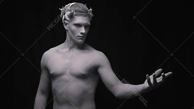 Creepy statue of the ancient man lifts his arm and looks