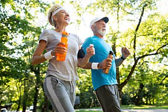 Fitness, sport, people, exercising and lifestyle concept - senior couple running