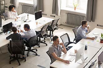 Diverse office workers using computers in modern corporate space