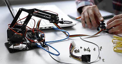 Robotics engineer programming robot arm for automation project