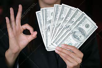 Business woman displaying a spread of cash over, spending money or profit from business operations concept