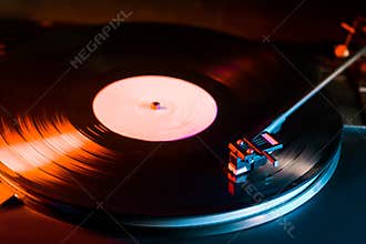Cinemagraph loop vinyl record player turntable with its stylus running along music plate. Neon. Retro-styled spinning