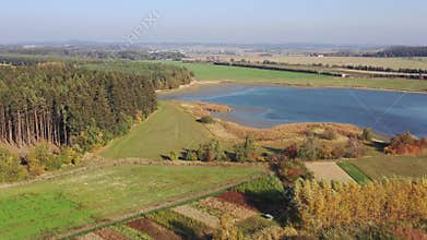 Aerial video of typical european breeding pond. Beautiful country with fields, forests and ponds