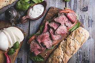 Steak sandwich, sliced roast beef, cheese,spinach leaves,tomato
