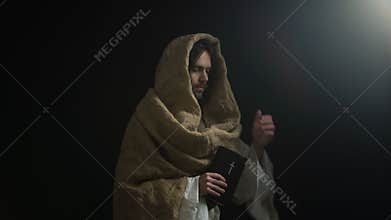 Jesus coming out of darkness and giving holy bible, concept of belief in god