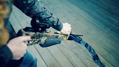 Girl inserts arrow into crossbow