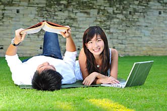Couple In Love In The park reading and surfing