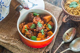 Maroccan lamb tajine with couscous garnished with fresh coriander leaves