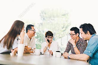 Diverse group of five Asian business person in team meeting at coffee shop or modern office. Strategic brainstorm, small business