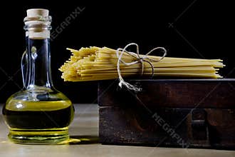 Pasta and olive oil on an old kitchen table. Recipes in old books in the kitchen on a wooden table.