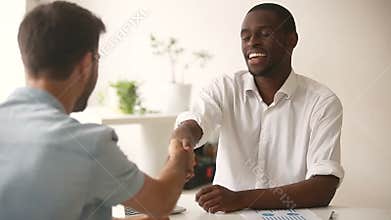 Happy satisfied diverse businessmen making commitment handshaking after successful negotiations