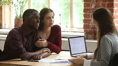 Young multi-ethnic couple planning mortgage meeting with real estate agent