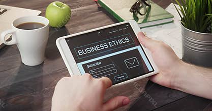 Reading business ethics info using digital tablet at desk