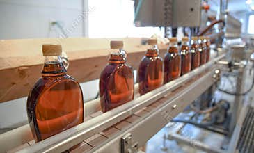 Bottles of fresh maple syrup on the production line at Ben`s Sugar Shack in Temple, N.H., USA, March 24, 2018.